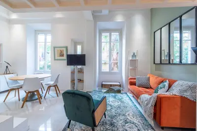 a living room with an orange couch and a table at Happyfew Liberty in Nice