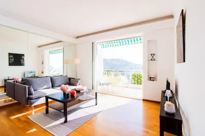 a living room with a couch and a table at Terrace on the Bay 2 Villefranche-sur-Mer, AP4243 by Riviera Holiday Homes in Villefranche-sur-Mer