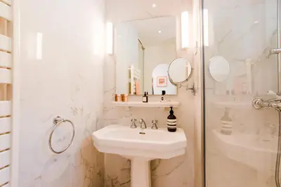 a white bathroom with a sink and a shower at Terrace on the Bay 2 Villefranche-sur-Mer, AP4243 by Riviera Holiday Homes in Villefranche-sur-Mer
