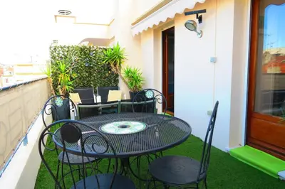 a patio with a table and chairs on a balcony at Nestor&Jeeves - ANDRIOLI TERRASSE - Central - Close beach - Top floor in Nice