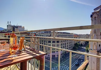a balcony with a table with wine glasses on it at Nestor&Jeeves - NOTRE DAME - Hyper center - Top floor - 180 view in Nice