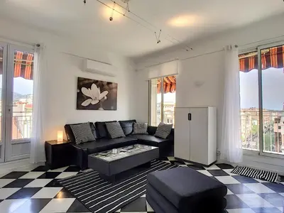 a living room with a black couch and a checkered floor at Nestor&Jeeves - NOTRE DAME - Hyper center - Top floor - 180 view in Nice
