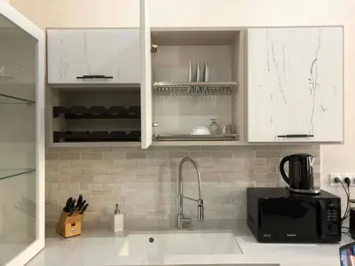 a kitchen with white cabinets and a sink at Petit Palace in Old Nice in Nice