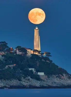 a full moon rising over a lighthouse on a hill at Great and light private room in the heart of Nice in Nice