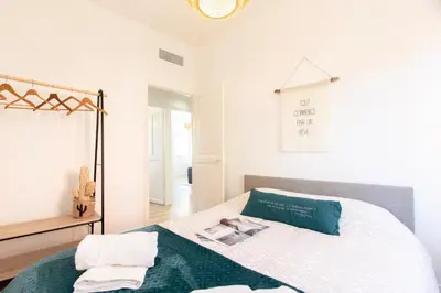 a white bedroom with a bed with a green blanket at Maison Bianchi - Villefranche in Villefranche-sur-Mer