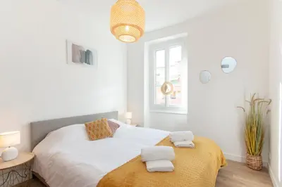 a white bedroom with a bed with towels on it at Maison Bianchi - Villefranche in Villefranche-sur-Mer
