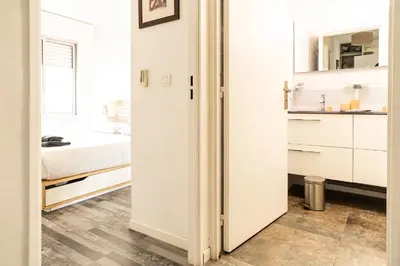 a white room with a bed and a bathroom at Le Syrius in Nice