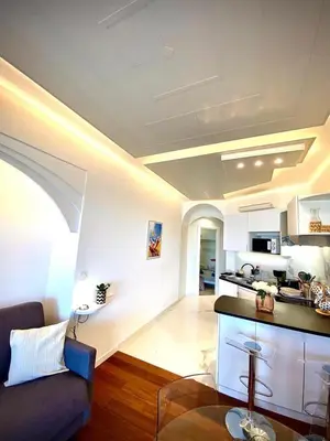 a living room with a couch and a kitchen at LE ROCAMARE -Superb-Atypical Sea view-A.C-WIFI in Nice