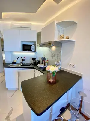 a kitchen with white cabinets and a black counter top at LE ROCAMARE -Superb-Atypical Sea view-A.C-WIFI in Nice