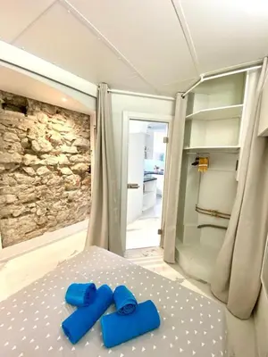 two blue slippers are sitting on top of a bed at LE ROCAMARE -Superb-Atypical Sea view-A.C-WIFI in Nice
