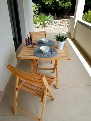 a wooden table and a chair on a patio at Villa LE CIEL D EZE in Èze