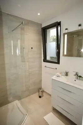 a bathroom with a shower and a sink and a mirror at Villa LE CIEL D EZE in Èze