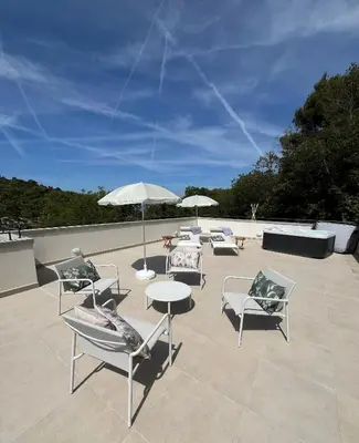 a group of chairs and tables with umbrellas on a patio at Villa LE CIEL D EZE in Èze