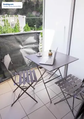 a table and two chairs with a laptop on it at Anicesleep Superbe appart au calme et à 5 mn de la Prom in Nice