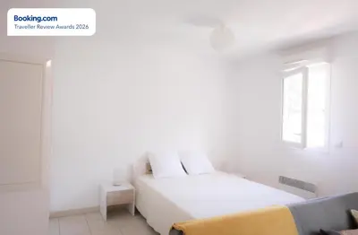 a white bedroom with a bed and a window at Anicesleep Superbe appart au calme et à 5 mn de la Prom in Nice