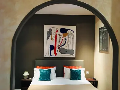a bedroom with a bed and a desk and a door at Hotel Villa La Tour in Nice