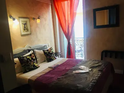 a hotel room with a bed with a window at Hotel Villa La Tour in Nice
