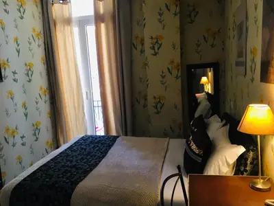 a bedroom with a bed and a lamp and a mirror at Hotel Villa La Tour in Nice
