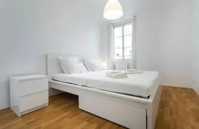 a white bedroom with a white bed and a window at BIG WHITE in Nice