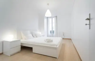 a white bedroom with a white bed and a window at BIG WHITE in Nice