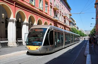 a train is traveling down a city street at Lovely Apartment Heart of Golden Square Fiber Wifi in Nice