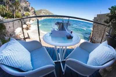 a balcony with two chairs and a table and the ocean at Hotel Cap Estel in Èze