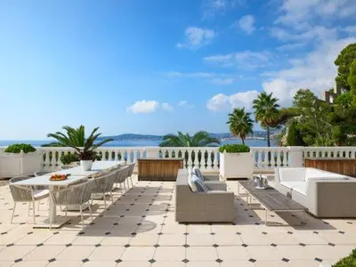 a patio with a table and chairs and the ocean at Hotel Cap Estel in Èze