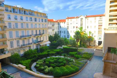a garden in the middle of a city with buildings at Nestor&Jeeves - PALAIS MEDITERRANEE TERRASSE - Central - Very close sea in Nice