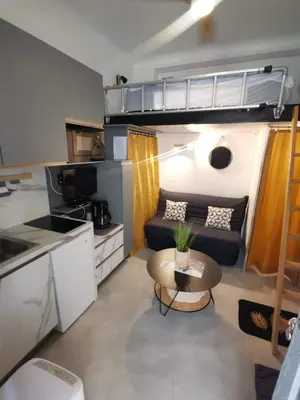 a small living room with a couch and a table at Studette 