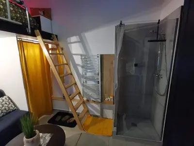 a bathroom with a shower and a ladder next to a shower at Studette 