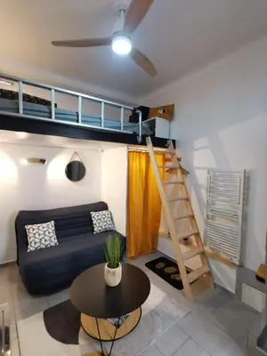 a living room with a couch and a bunk bed at Studette 