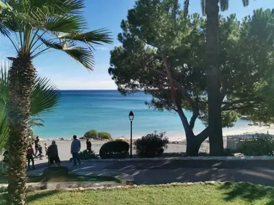 a group of people walking on a sidewalk near the beach at Studette 