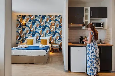 a hotel room with a bed and a blue chair at Aparthotel AMMI Nice Massena - ex Ajoupa in Nice
