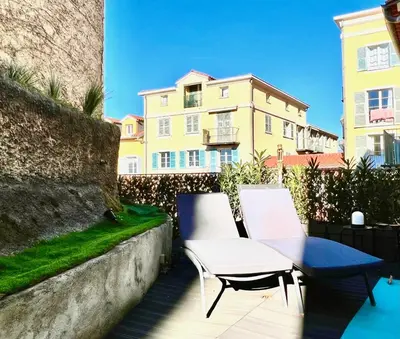 a table and chairs on a patio with a building at ApartHotel Riviera - Terrasse Loft de la Providence - Vieille Ville - Esprit Loft en 2 pices AC in Nice