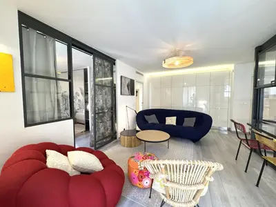 a living room with a red couch and a table at ApartHotel Riviera - Terrasse Loft de la Providence - Vieille Ville - Esprit Loft en 2 pices AC in Nice