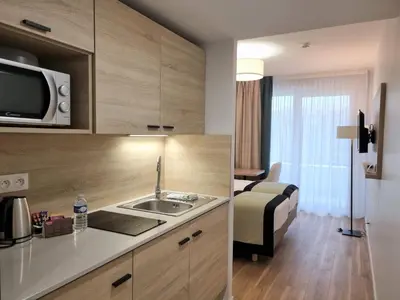 a hotel room with a sink and a bedroom at Residhome Nice Aéroport in Nice