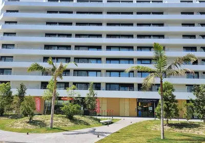 an apartment building with palm trees in front of it at Residhome Nice Aéroport in Nice