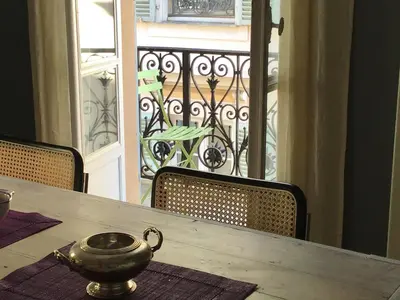 a table with a tea pot on top of it on a balcony at Modern, traditional , bright and stylish appartement in Nice
