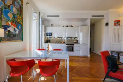 a kitchen with a white table and red chairs at Victor Hugo Palais AP3061 by Riviera Holiday Homes in Nice