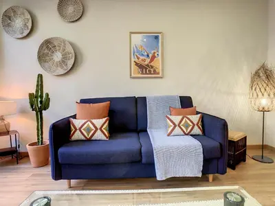 a blue couch with pillows in a living room at Nestor&Jeeves - CACTUS RIVIERA - Hyper center - Very close sea and Place Massena in Nice