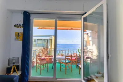 a room with a balcony with a view of the ocean at Le Béryl in Nice