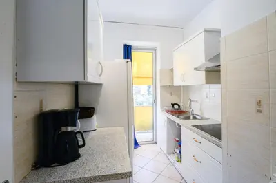 a kitchen with white cabinets and a refrigerator at Le Béryl in Nice