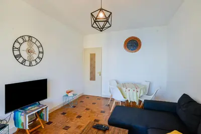 a living room with a couch and a clock on the wall at Le Béryl in Nice
