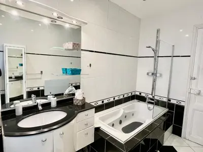 a bathroom with a sink and a bath tub at Joli appartement spacieux à 3 min à pied de la mer in Nice