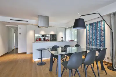 a dining room and kitchen with a glass table and chairs at Sublime Appartement Promenade des Anglais RDJ in Nice