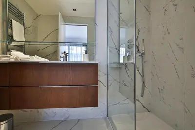 a bathroom with a glass shower and a sink at Sublime Appartement Promenade des Anglais RDJ in Nice