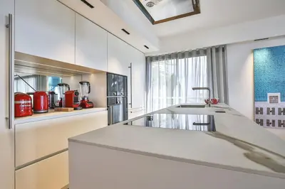 a white kitchen with a sink and a counter at Sublime Appartement Promenade des Anglais (2) in Nice
