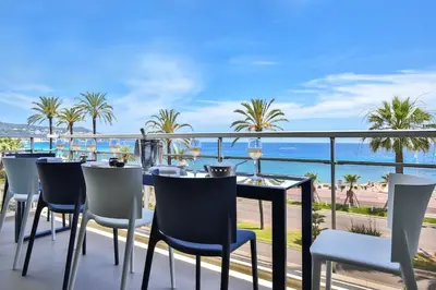 a table and chairs on a balcony with a view of the ocean at Sublime Appartement Promenade des Anglais (3) in Nice