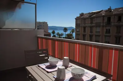 a table on a balcony with a view of a city at Stylish Studio in only 50 meters from beach ! in Nice