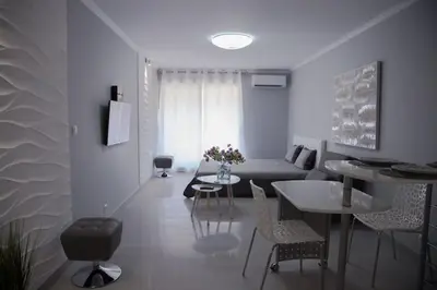 a living room with a couch and a table and chairs at Stylish Studio in only 50 meters from beach ! in Nice